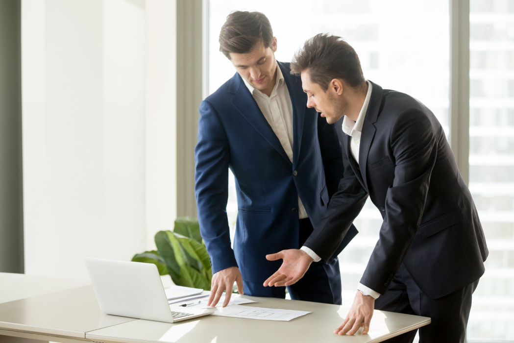 Businessman conducting presentation with business documents to convince investor to finance project. Realtor explaining benefits of estate object when showing drawings or construction plan to client